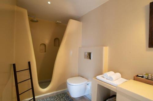 a bathroom with a toilet and a sink at Piperi On The Rocks in Naousa