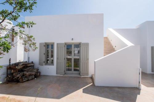 a white house with white walls and a staircase at Piperi On The Rocks in Naousa