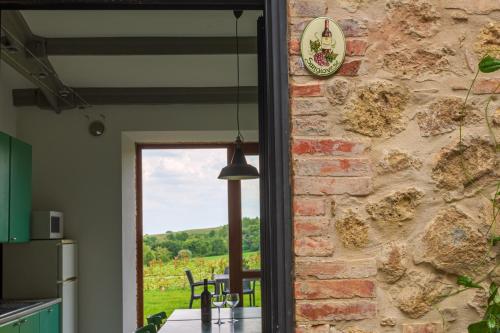 a kitchen with a stone wall and a window at Agriturismo Palazzo Bandino - Wine cellar, on reservation restaurant and spa in Chianciano Terme