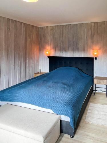 a bedroom with a blue bed and wooden walls at FourGotten in Sel