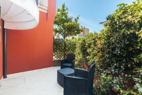 a patio with two chairs and an umbrella at Hotel Nicoletta in Santa Maria Navarrese