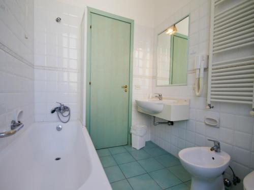 a bathroom with a tub and a toilet and a sink at Hotel Serapo in Gaeta