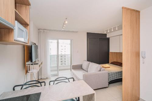 a living room with a couch and a tv in a room at Studio Central Independência 915 in Juiz de Fora