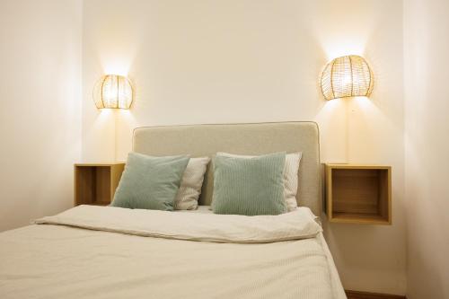a bedroom with a bed with two lights on it at OrestaLiving - BrigittineurLände in Vienna