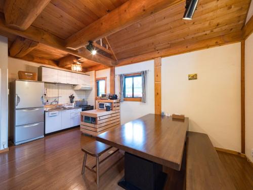 a kitchen with a large wooden table in a room at 八ヶ岳 HOKUTO BASE -Yatsugatake- in Hokuto