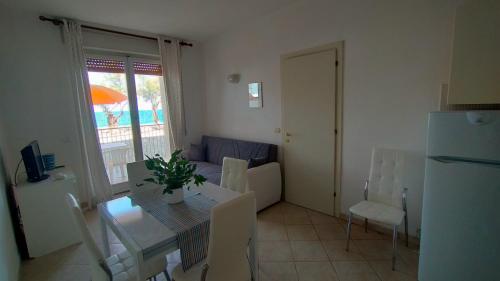 a small living room with a table and a couch at P313 nr 102 trilocale sul mare con ombrellone in prima fila in Marcelli