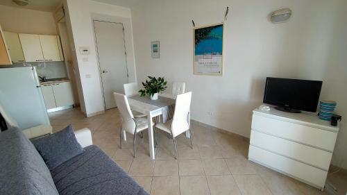 a living room with a couch and a table with chairs at P313 nr 102 trilocale sul mare con ombrellone in prima fila in Marcelli