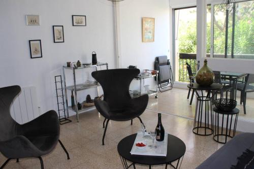 - un salon avec des chaises et des tables noires dans l'établissement Spacieux T2 avec parking privatif proche du Port et de la plage-4RM217, à Saint Cyprien Plage