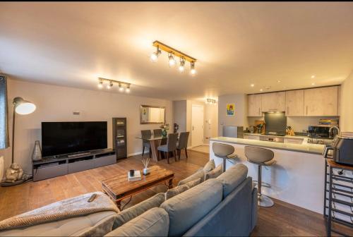 a living room with a couch and a kitchen at Modern apartment in the city centre in Southampton