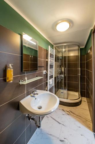 a bathroom with a sink and a shower at Pension Michelangelo in Eisenach