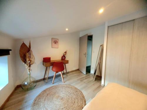 ロアンヌにあるL'Or du temps, appartement cosyのリビングルーム(テーブル、赤い椅子付)
