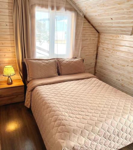 a bed in a small room with a window at Vinor Cottage in Volosyanka