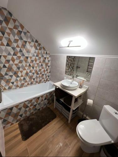 a bathroom with a sink and a tub and a toilet at Vinor Cottage in Volosyanka