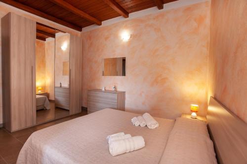 a bedroom with a bed with towels on it at Appartamento immerso nel verde in San Teodoro