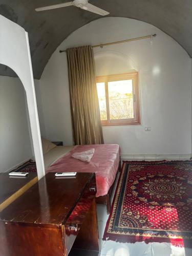 a bedroom with a bed with a dresser and a window at Nile View Guest House in Aswan