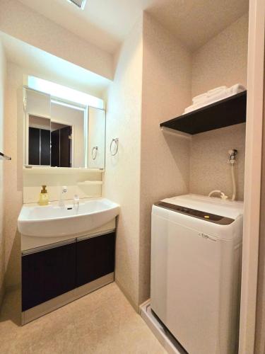 a bathroom with a sink and a washing machine at 嵐 Arashi BNB 日本橋 No8111 in Osaka