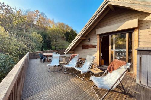 une terrasse en bois avec des chaises et une table dans l'établissement Appartement du Rosay - Welkeys, à Saint-Gervais-les-Bains