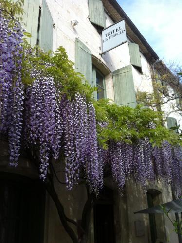a bunch of purple flowers hanging off the side of a building at Hotel Les Templiers in Aigues-Mortes