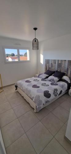 une chambre avec un lit dans une pièce dans l'établissement Appartement neuf 39m2 avec balcon à 250m de la plage, à Saint-Vincent-sur-Jard