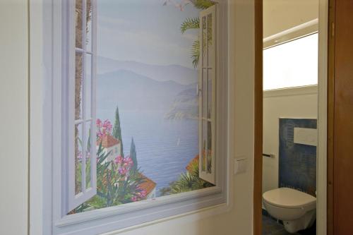 a bathroom with a window with a painting of the ocean at Parco Belmonte: Vista Fantastica in Brezzo