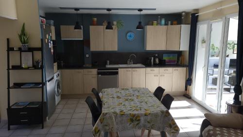 une cuisine avec une table et une cuisine avec une salle à manger dans l'établissement Villa aux Citrons, à La Garde