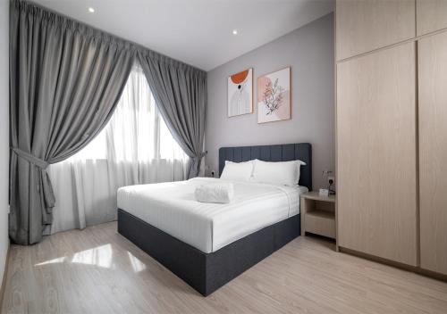 a bedroom with a bed and a large window at Iconic Regency Service Residences, managed by Iconic Hotel in Bayan Lepas