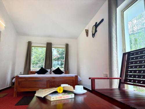 a bedroom with a bed and a table and a window at Earth songs by Green leaves - 10 kms from kotagiri in Kotagiri