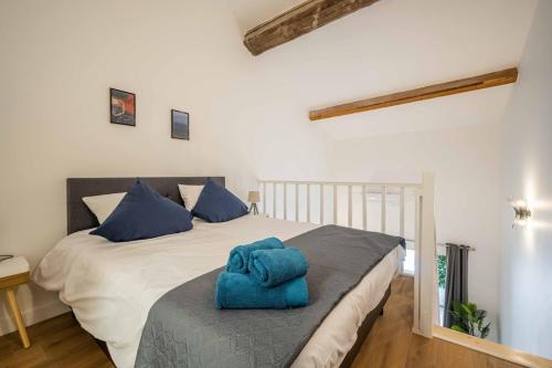 une chambre avec un lit avec une serviette bleue dessus dans l'établissement L'Hippocrate Duplex à deux pas des Halles, à Narbonne