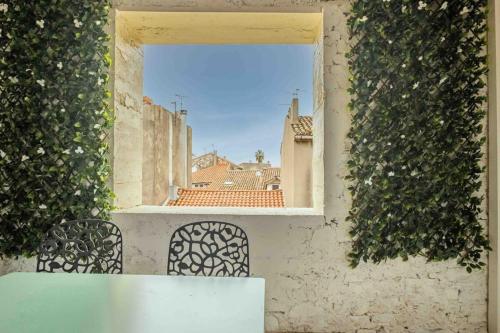 - une vue depuis la fenêtre d'un bâtiment avec lierre dans l'établissement L'Hippocrate Duplex à deux pas des Halles, à Narbonne