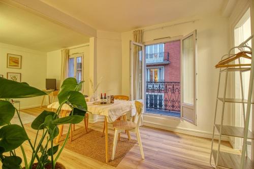 une salle à manger avec une table et une grande fenêtre dans l'établissement Maison Boueno II - Guest house 15' from Paris Center, à Enghien-les-Bains