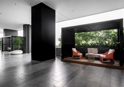 a lobby with orange and white chairs and a couch at Iconic Regency Service Residences, managed by Iconic Hotel in Bayan Lepas