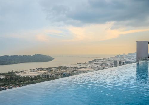 a infinity pool with a view of the water at Iconic Regency Service Residences, managed by Iconic Hotel in Bayan Lepas