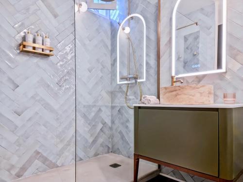 une salle de bain avec une douche avec un lavabo et un miroir dans l'établissement Luxury Flat with balcony near Arc de Triomphe, à Paris