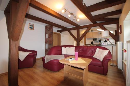 un soggiorno con un divano rosso e un tavolo di Kapitänshaus FW 4 OG re a Wustrow