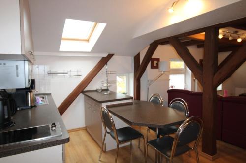 una cucina e una sala da pranzo con tavolo e sedie di Kapitänshaus FW 4 OG re a Wustrow