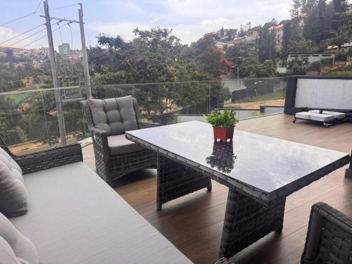 a table with a potted plant on top of a balcony at Cascadia Apartments Kigali in Kigali