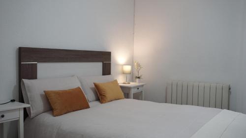 a bedroom with a large white bed with two tables at Casa Abuela Carmen in Arévalo
