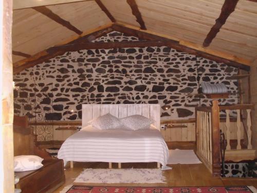 a bedroom with a bed in a stone wall at Notre Bergerie in La Chaise-Dieu