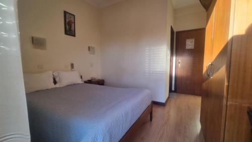 a small bedroom with a bed and a wooden floor at Hotel Bela Vista in Viseu