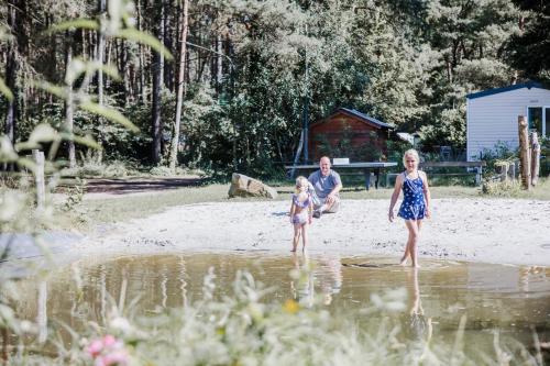 a man and two children standing in the water at Camping Siesta in Lille