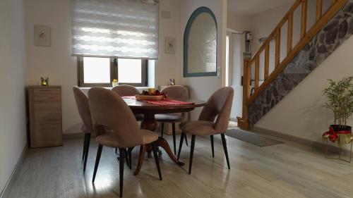a dining room with a table and chairs and a staircase at Casa Abuela Carmen in Arévalo