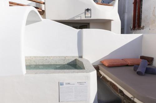 a bed with two pillows on top of it at Aperto Suites - Adults Only in Fira
