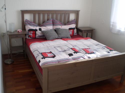 a bed with a red and white quilt and pillows at Apartment Za Poštou in Bělkovice