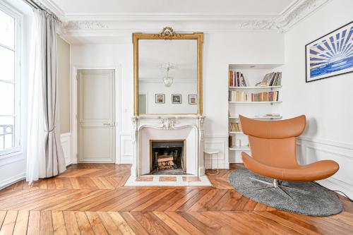 - un salon avec une chaise et une cheminée dans l'établissement Appartement de luxe - Assemblée Nationale, à Paris