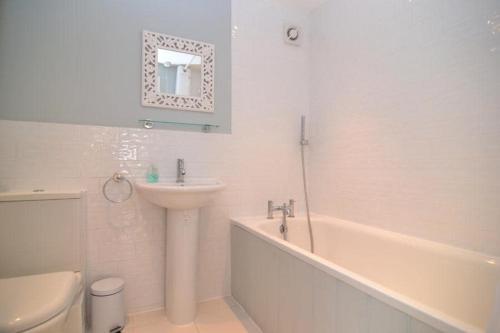 ein Badezimmer mit Waschbecken, Badewanne und Toilette in der Unterkunft Charming Cottage with Roof Terrace in Twickenham
