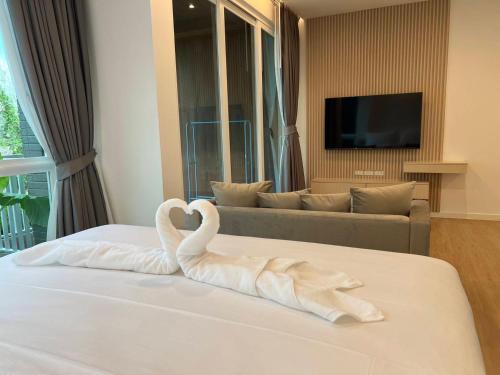 a room with a bed with swans made out of towels at Beachfront Bliss at Naiyang Phuket by ALPHATEL in Phuket