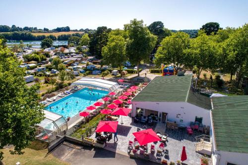 - une vue sur la piscine et ses parasols rouges dans l'établissement Domaine Résidentiel de Plein Air Le Conleau, à Vannes
