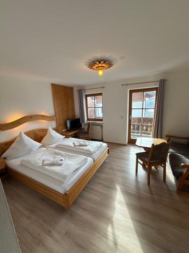 a bedroom with a large bed and a couch at Gasthof Und Hotel Maria Gern in Berchtesgaden