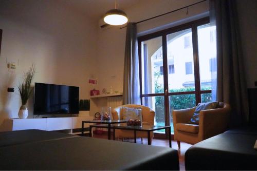 a living room with a television and a table and chairs at Roma 2 Apartment - THE V Collection in Turate