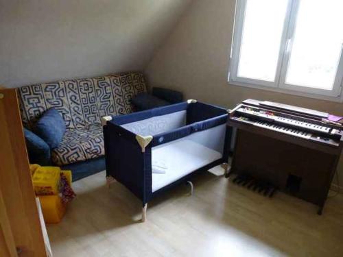 a living room with a piano and a couch at Alsace nature et découvertes in Gunsbach